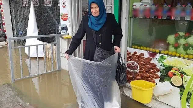 Evini su bastı, poşet giyerek suya girdi