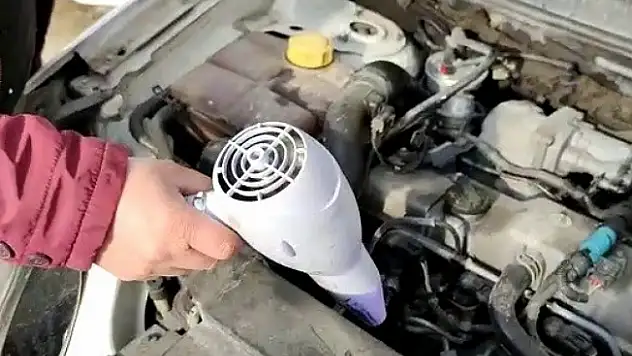 Saç kurutma makinesiyle donan aracını ısıttı