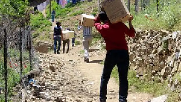 Köydeki çocuklar için sırtlarında kitap taşıdılar