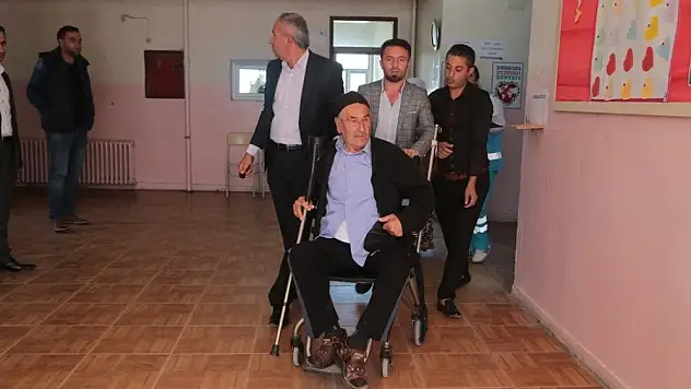 Sağlık ekipleri yaşlı adama yardım ederek oy kullandı